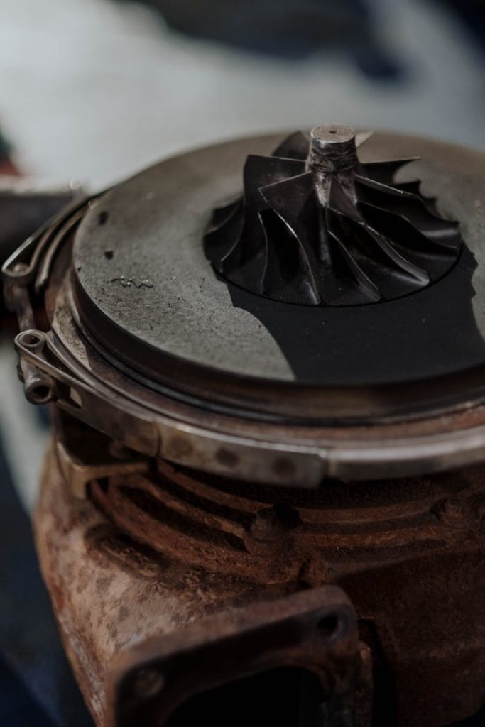 Detailed shot of a rusty turbocharger showing metal components and engine parts.